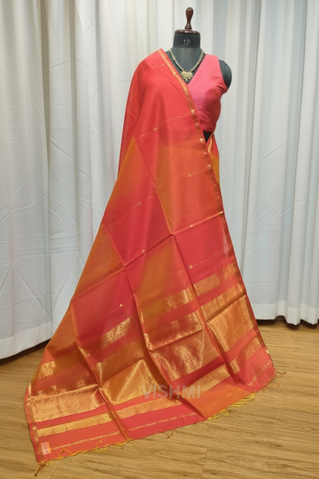 Red and orange saree with gold border on a wooden floor