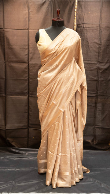 Beige saree on a mannequin against a plain background