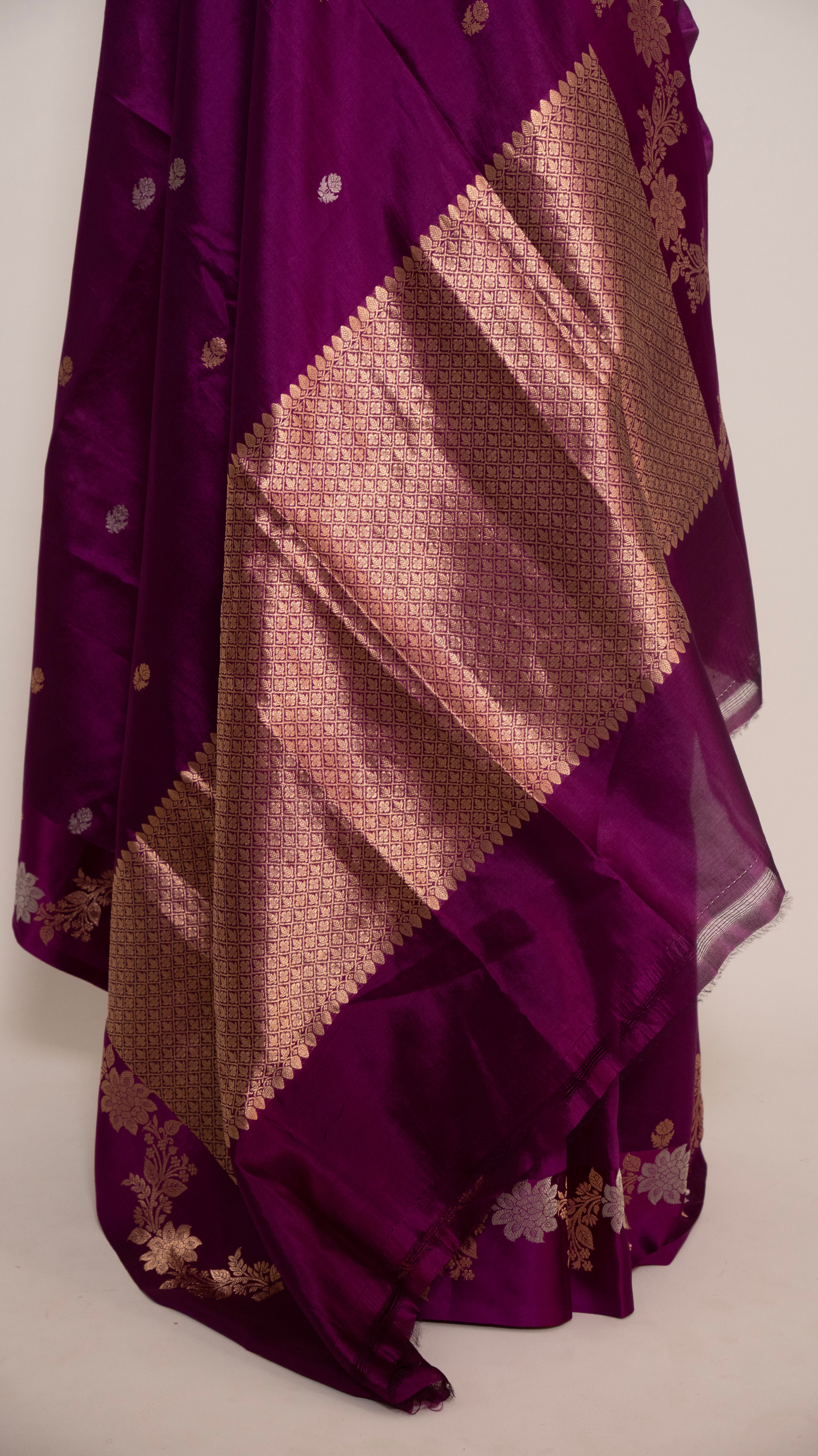 Purple and gold patterned fabric draped over a white background