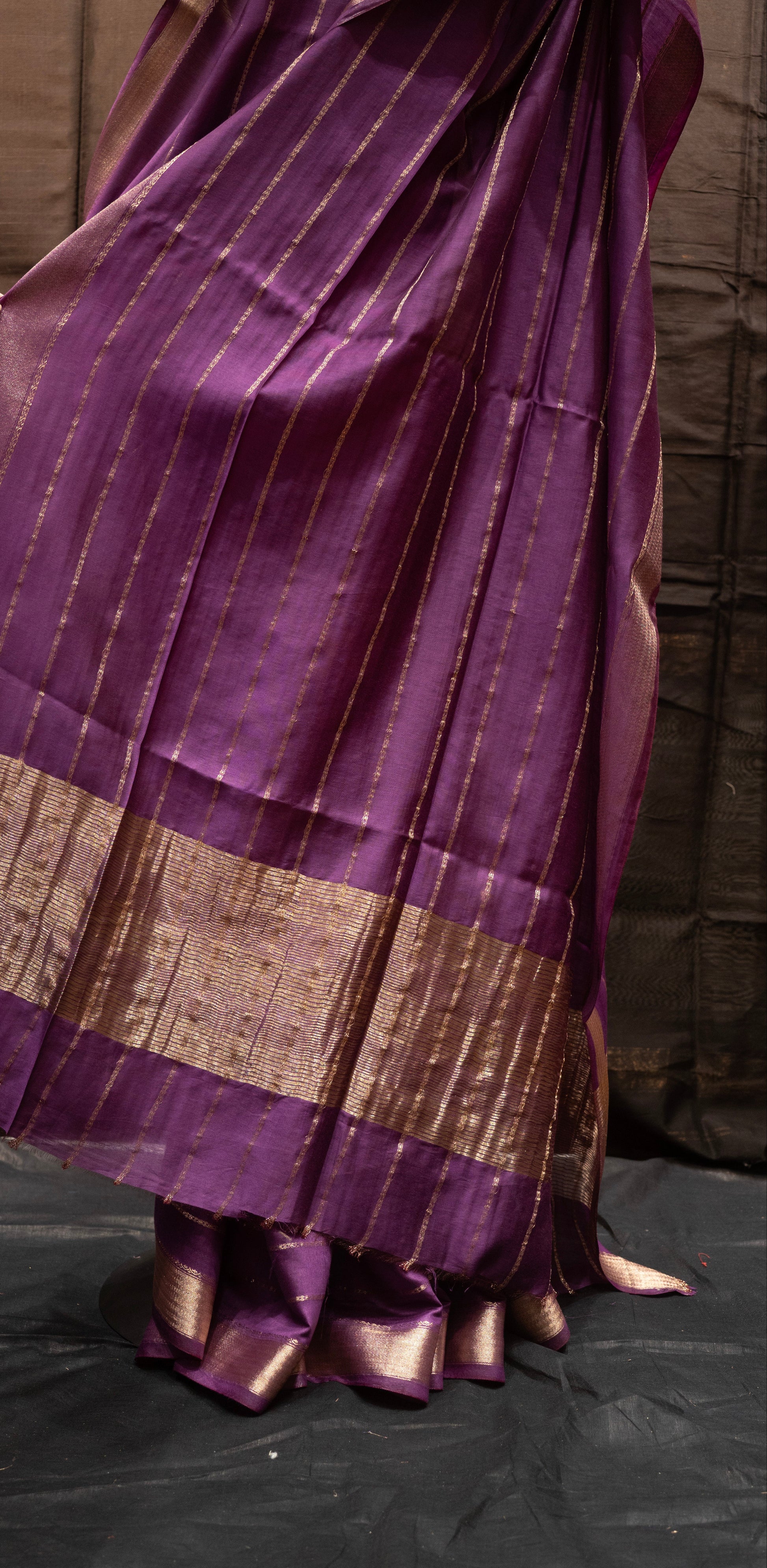 Purple saree with a brown border on a black background