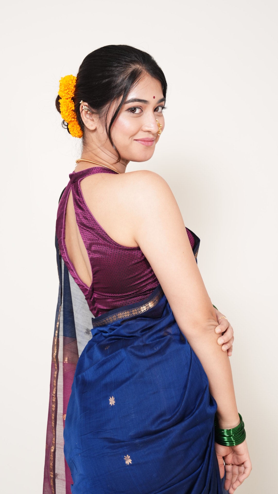 Woman wearing a blue saree with a white background