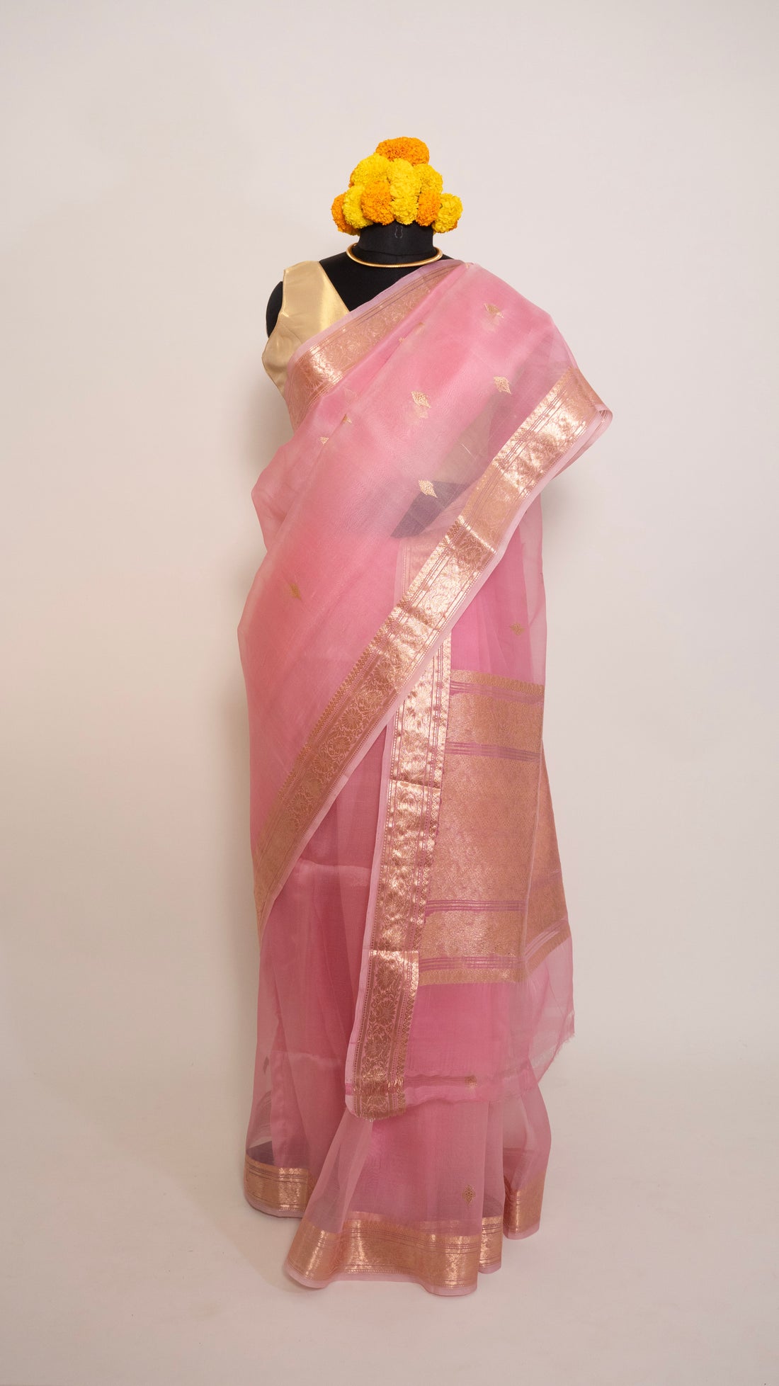 Pink saree with gold border on a white background