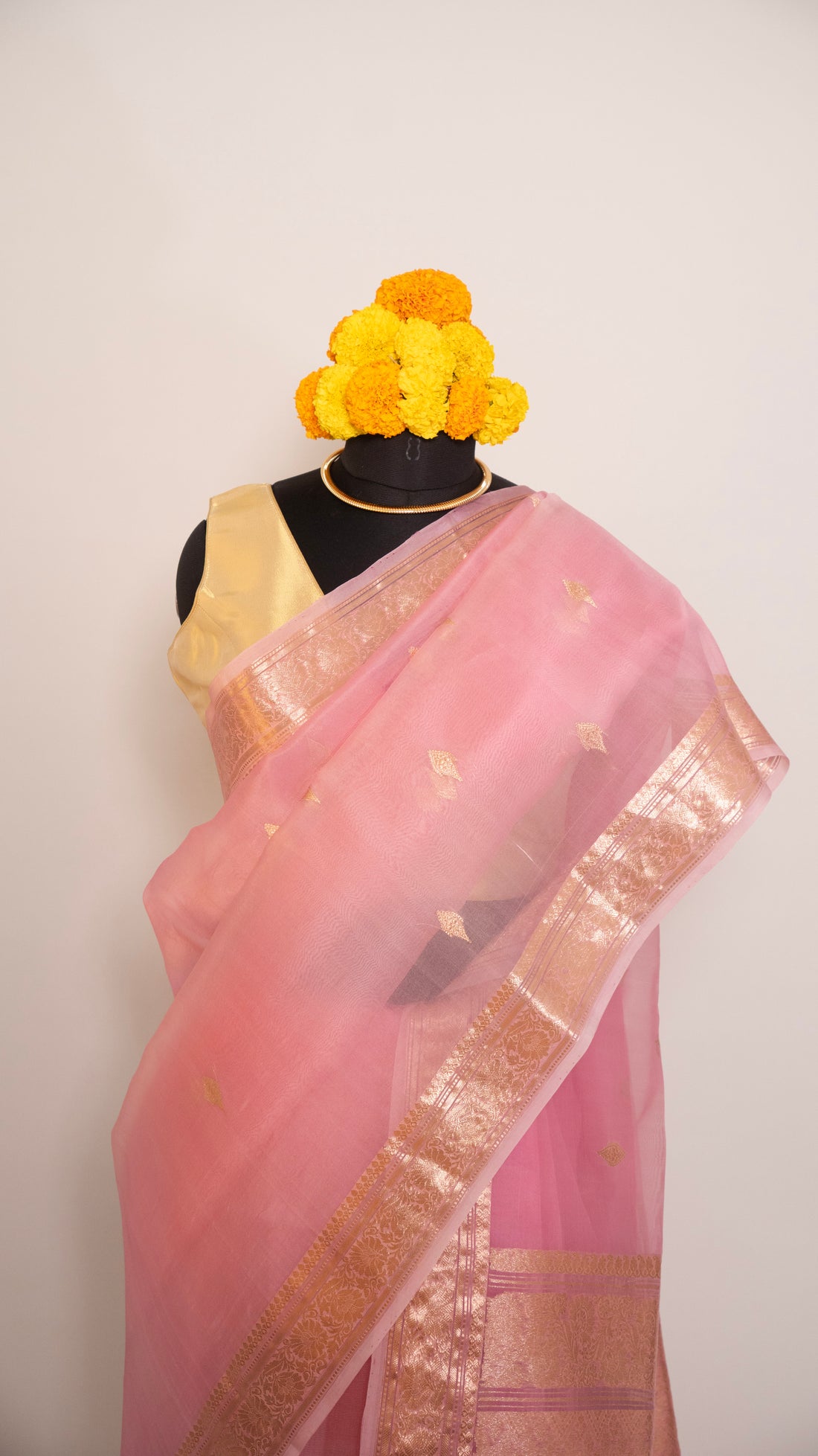 Pink saree with gold border on a white background
