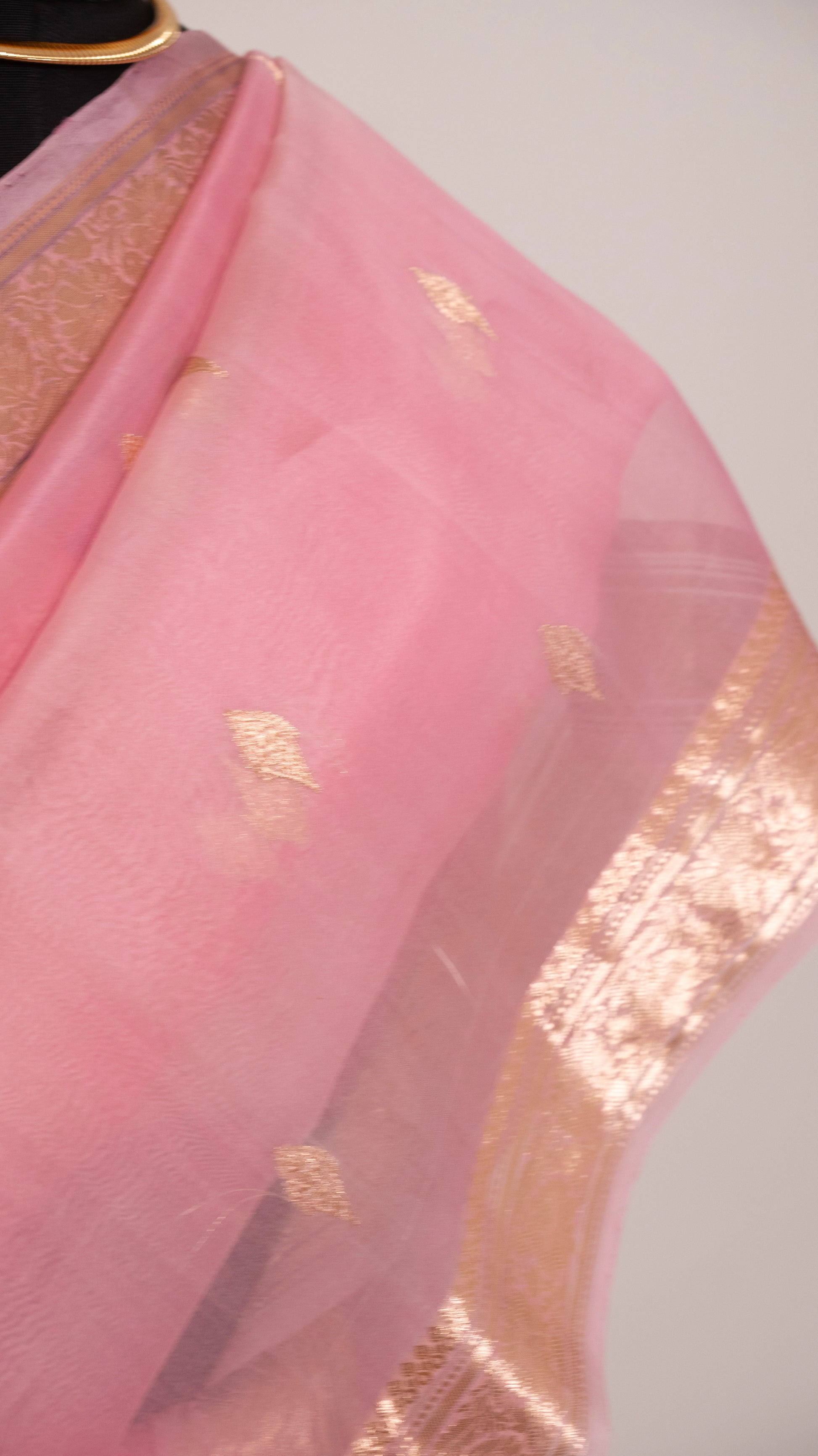Pink fabric with gold patterns on a white background
