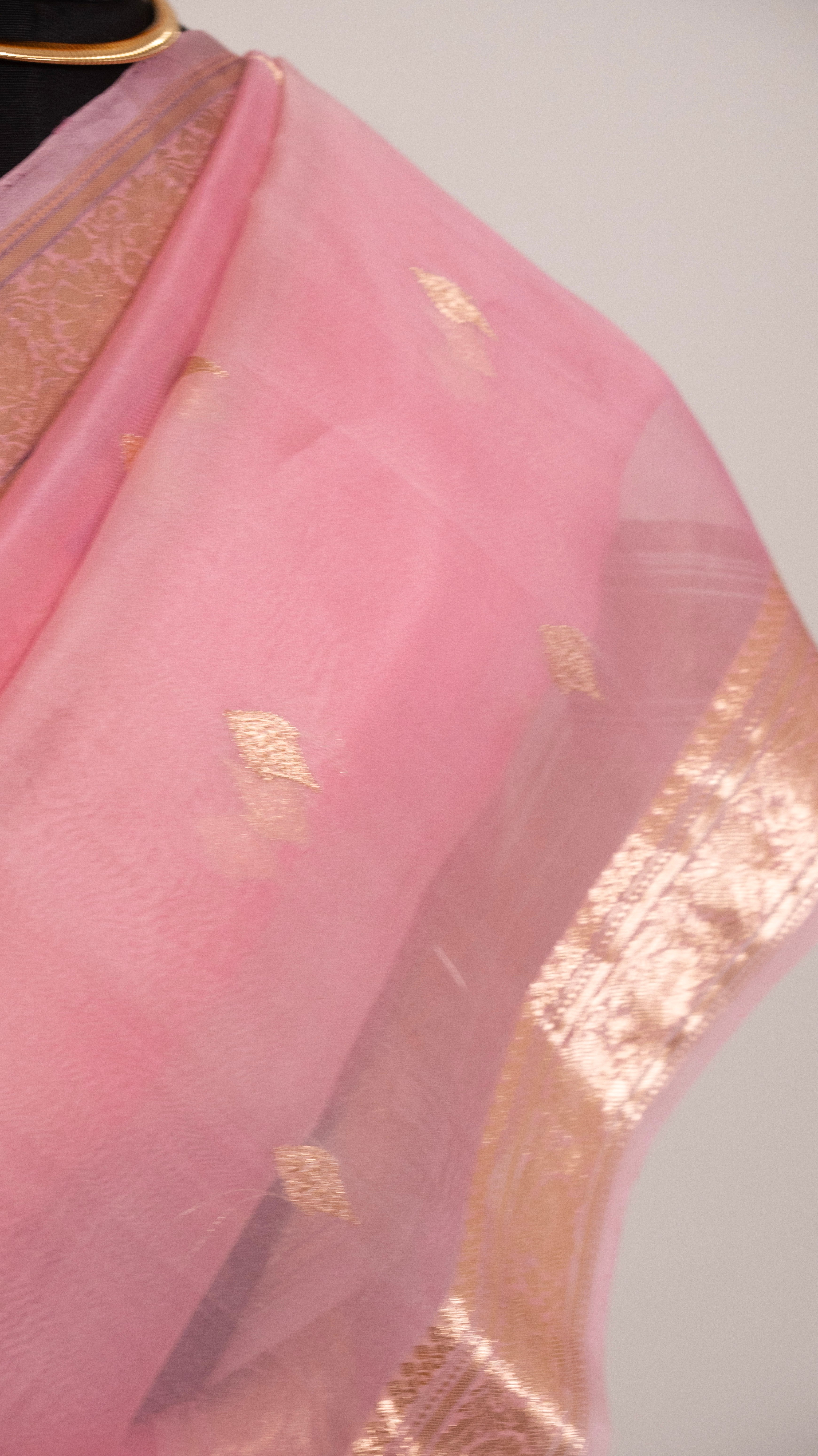Pink fabric with gold patterns on a white background
