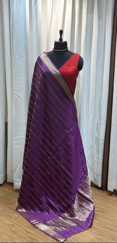 Purple fabric on a mannequin with a wooden floor and patterned rug in the background